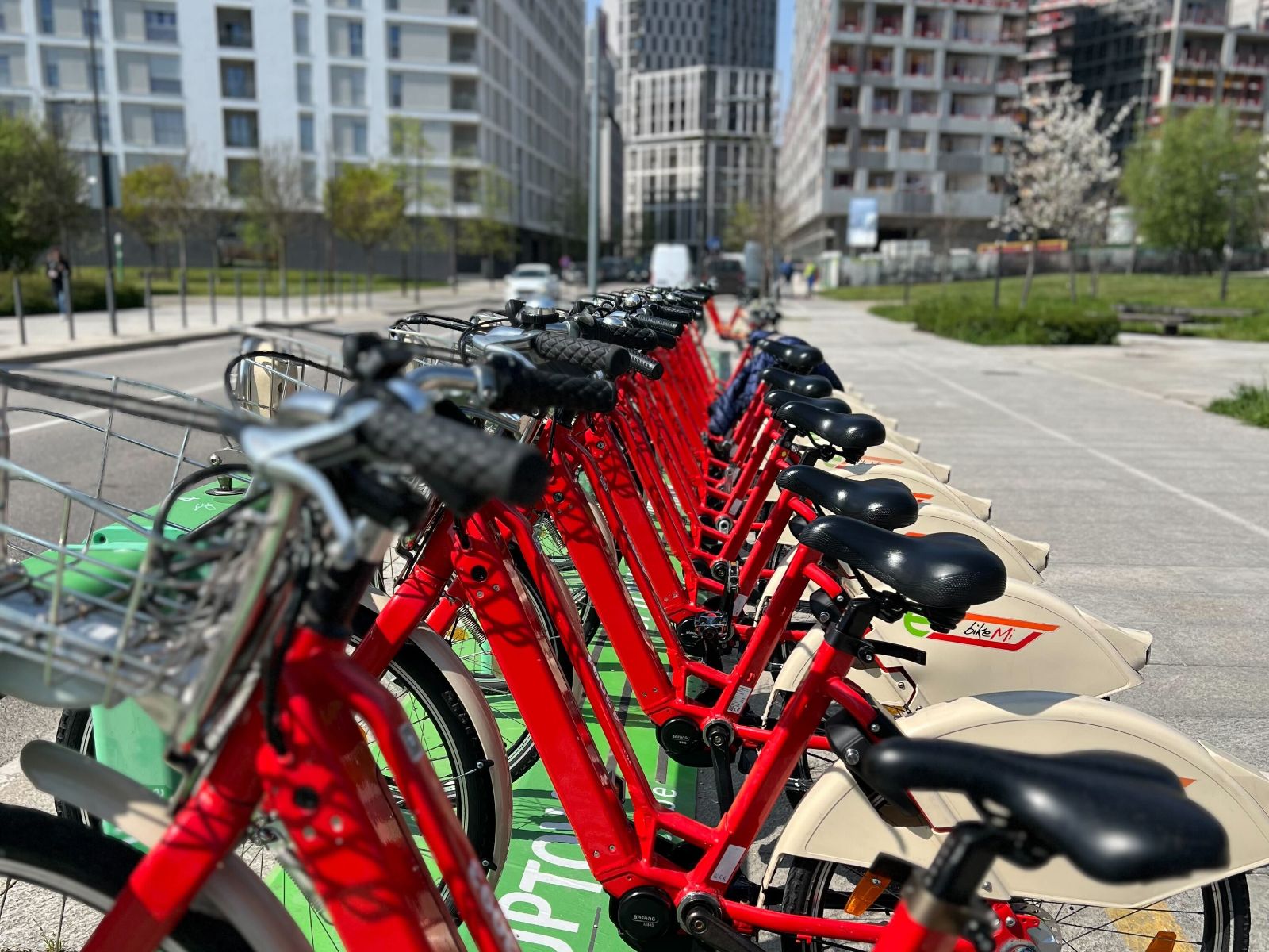 Row of red bike-share e-bikes docked at a city station