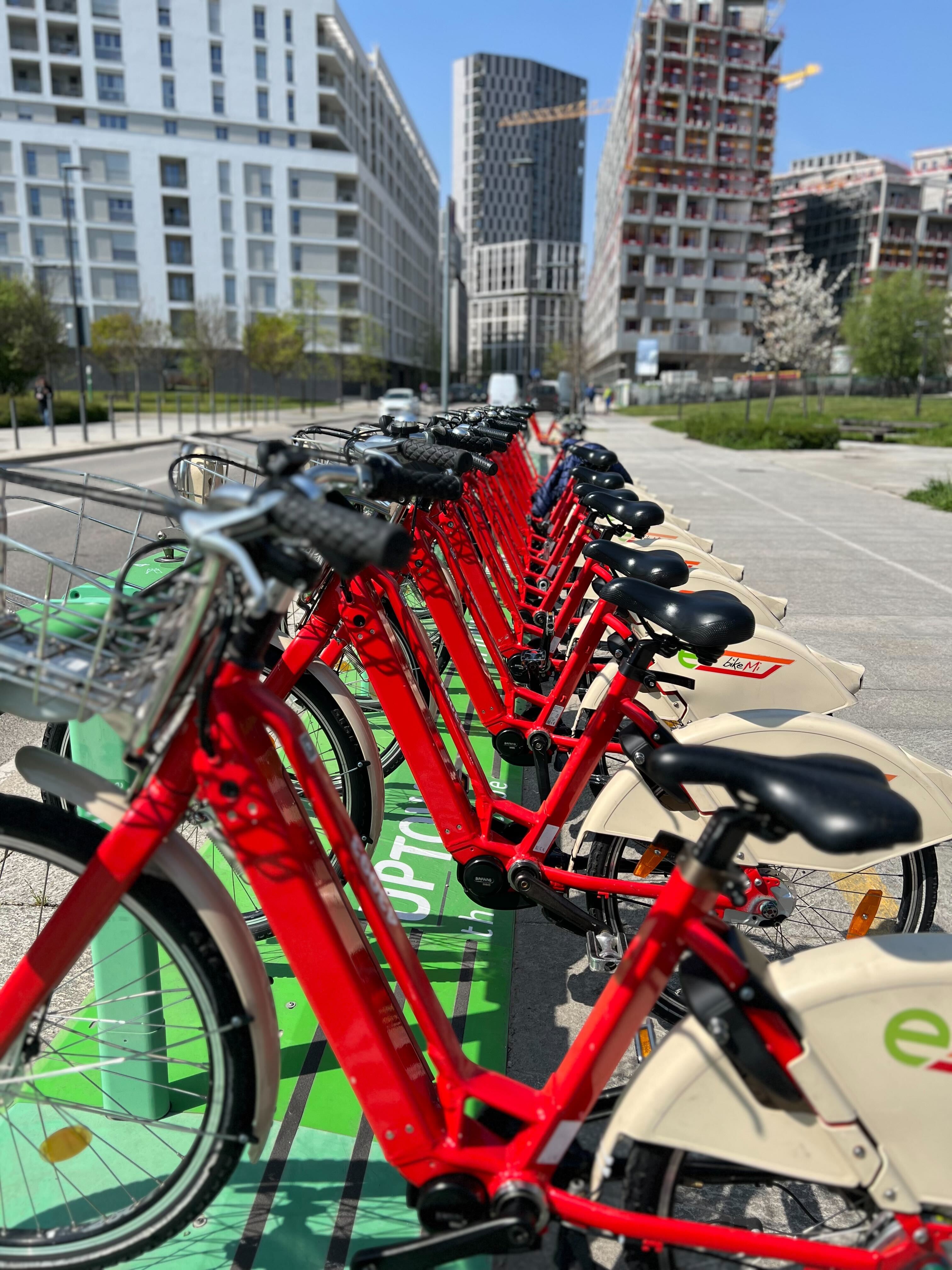 Row of red share e-bikes docked at a station, each fitted with a LINKA lock